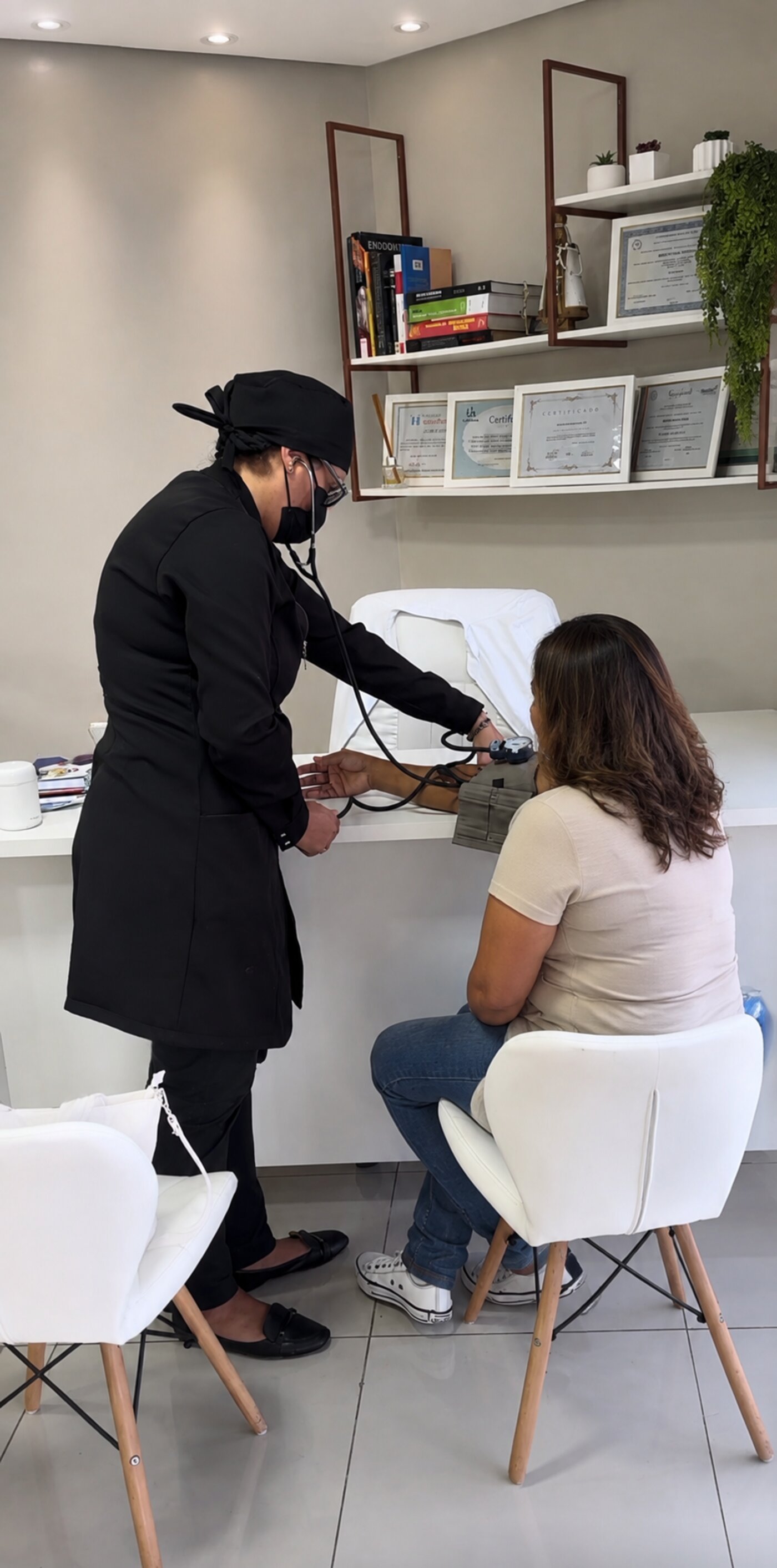Aferição de pressão de paciente antes de procedimento - Odontologia Oliveira